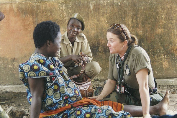 An Air National Guard nurse talks with a patient in Guinea with the help of a Guinea Army nurse.